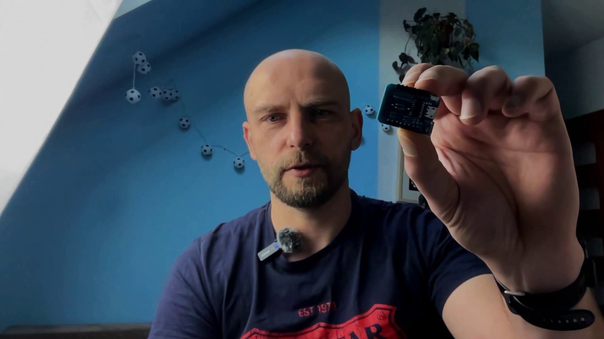 Mikrokontroler D1 mini z modułem ESP8266 trzymany w dłoni przed kamerą